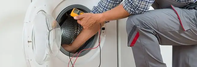 Dryer repair technician inspecting and repairing a clothes dryer in Springfield, MO