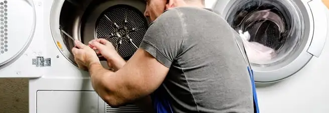 Dryer repair technician fixing a clothes dryer drum in Springfield, MO