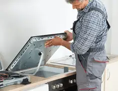 Appliance repair technician installing a built-in cooktop in Springfield, MO