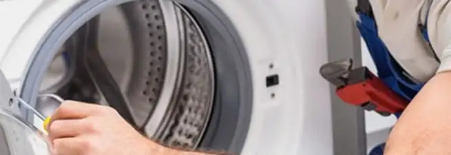 Appliance technician repairing a clothes dryer drum and internal parts in Springfield, MO