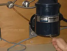 Garbage disposal repair technician tightening the mounting ring under a sink in Springfield, MO