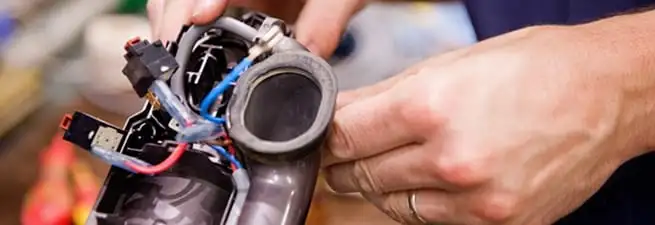 Vacuum repair technician reconnecting wiring and components in Springfield, MO