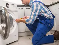 Washing machine repair technician servicing a front-load washer in Springfield, MO