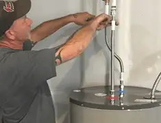 Water heater repair technician tightening supply line connections in Springfield, MO