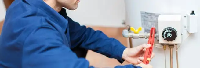 Water heater repair technician adjusting the temperature control and gas valve in Springfield, MO